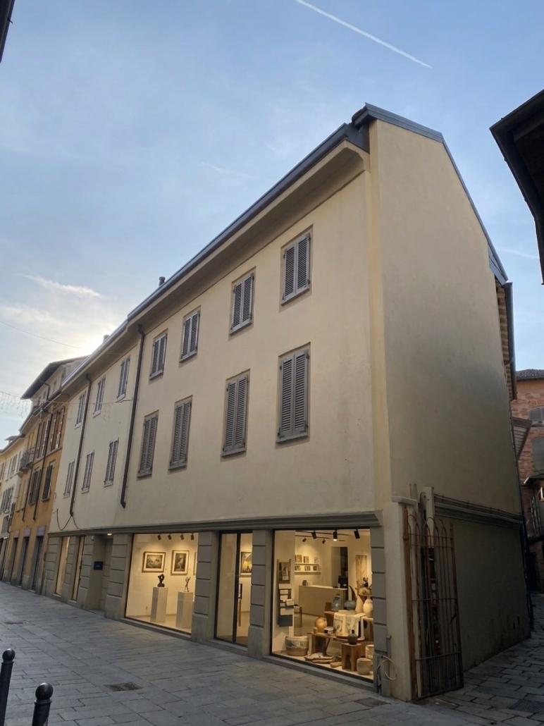 Centro Storico di Monza_01-PF-Archistudio Facciata d'angolo di un edificio nel centro storico di Monza, con vetrine illuminate al piano terra