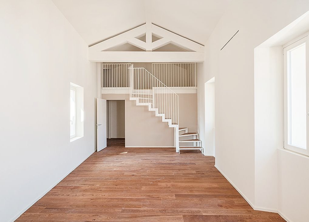 Centro Storico di Monza_05-PF-Archistudio Soggiorno a doppia altezza con soppalco, scala bianca e pavimento in parquet