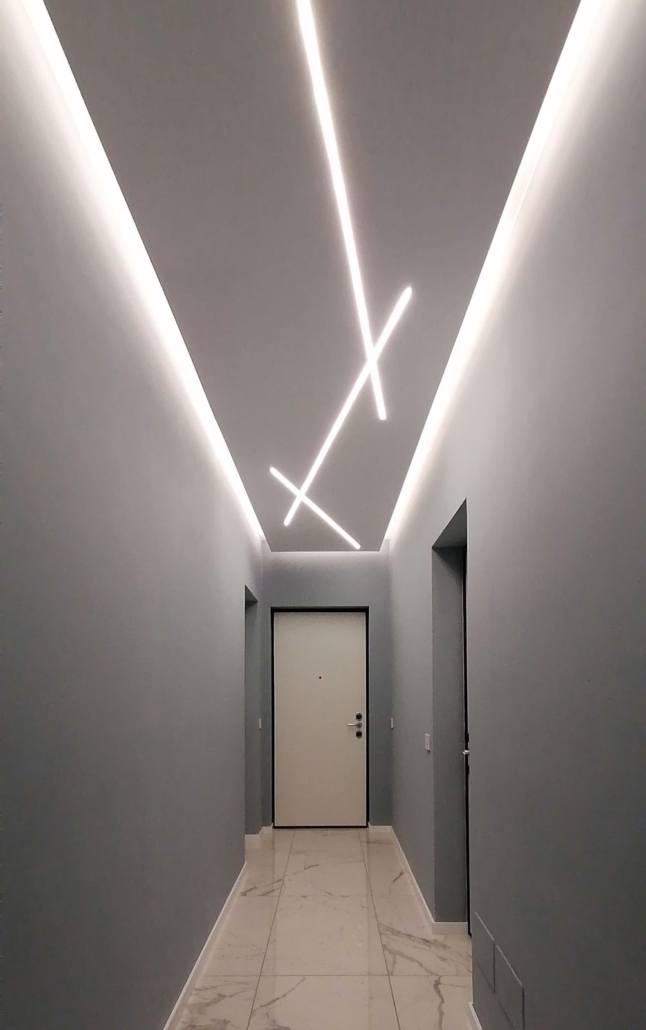 Centro Storico di Milano_02-PF-Archistudio Corridoio d'ingresso con luci lineari a soffitto, porta bianca e pavimento di marmo
