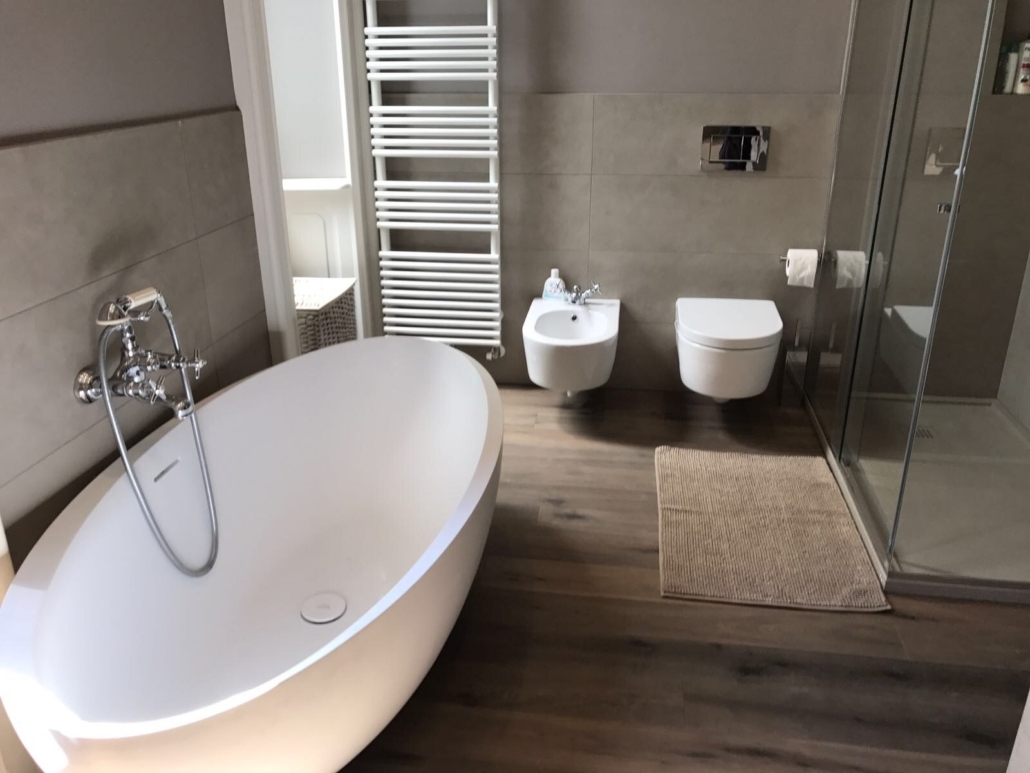 Appartamento Porta Venezia_02-PF-Archistudio Bagno con vasca freestanding, sanitari sospesi e doccia in cristallo